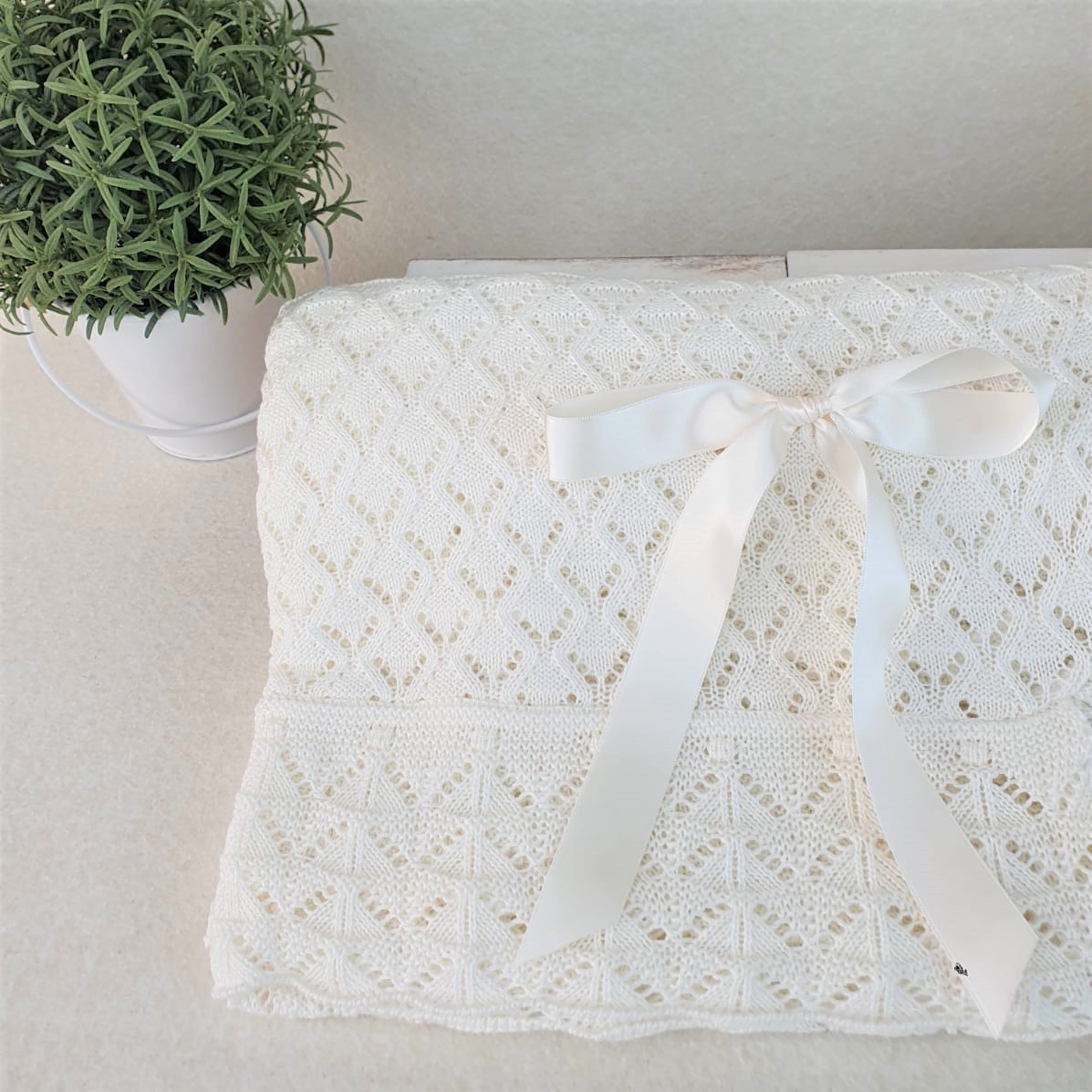 Toquilla con calados en forma de rombos y uves en el volante